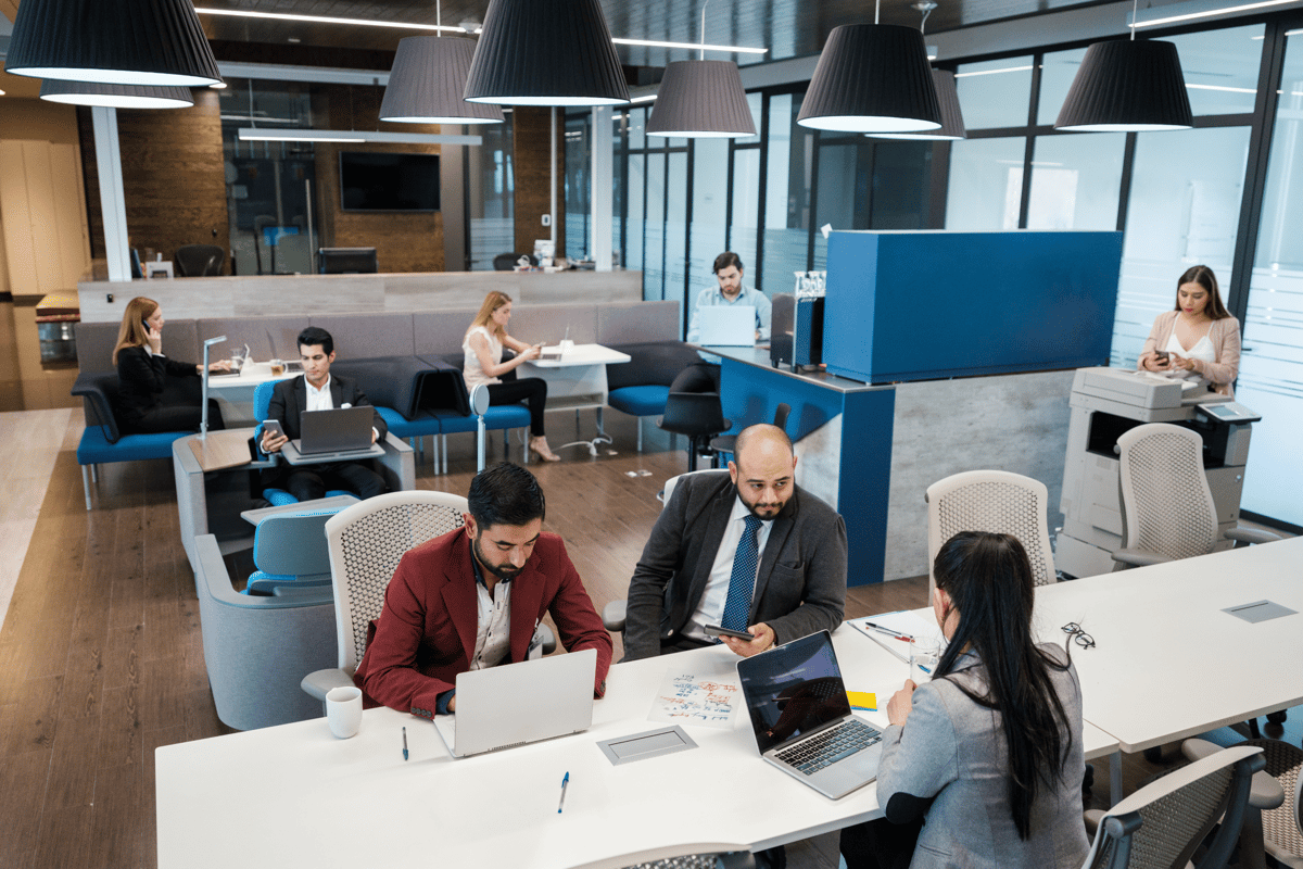 Business office with workers utilizing technology