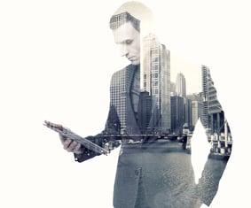 Double exposure of a businessman and a city using a tablet over white background.jpeg
