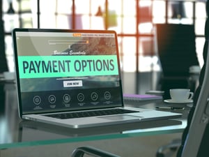 Workplace laptop on a glass desk that has overview on payment options