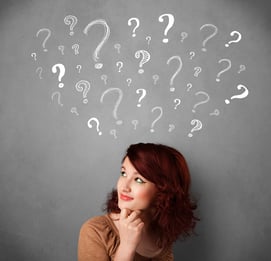 Pretty young woman thinking with sketched question marks all over her head.jpeg