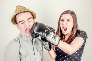 couple in a pretend fight, boxing gloves, woman hitting man with boxing gloves for fun. 